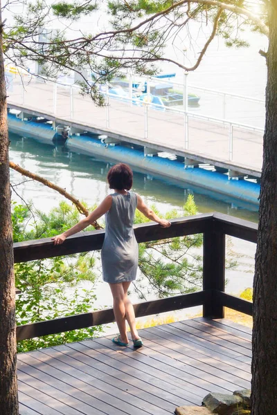 Una Donna Sul Ponte Guarda Lontananza Dietro Una Barca Vela — Foto Stock