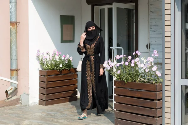市里一名身穿民族服装的穆斯林妇女离开了商店 — 图库照片
