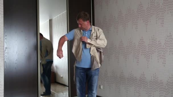 一个男人在自己身上检查撕破的旧夹克 — 图库视频影像