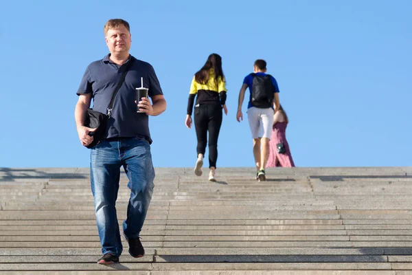 Взрослый Высокий Мужчина Быстро Бежит Широкой Лестнице Улице Стаканом Руке — стоковое фото
