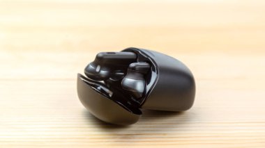 Modern kablosuz bluetooth kulaklıklar tahta arka planda şarj kutusunda.