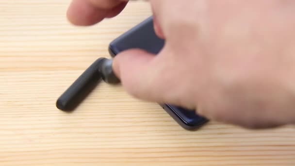 Mani stabilire cuffie wireless accanto allo smartphone su sfondo di legno — Video Stock