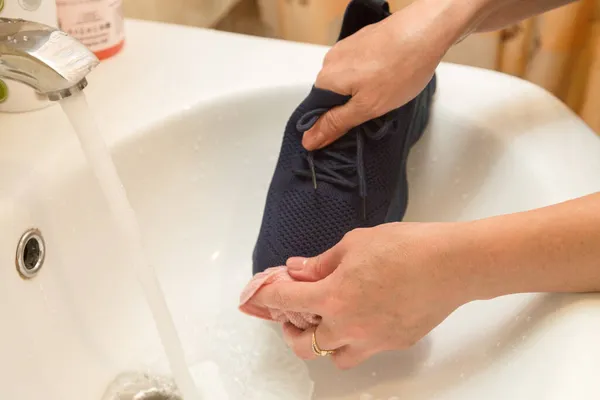 Las Manos Femeninas Lavan Las Zapatillas Azules Bajo Agua Corriente —  Fotos de Stock