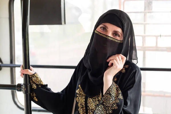 一名身穿民族服装的穆斯林妇女在城市公共交通中穿梭 — 图库照片