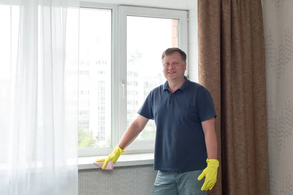 Dairesini Temizleyen Bir Adam Sarı Lastik Eldivenlerle Pencere Pervazlarını Siler — Stok fotoğraf