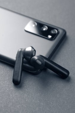 Modern cihazların cep telefonu kavramının panelinde şık kulaklıklar..