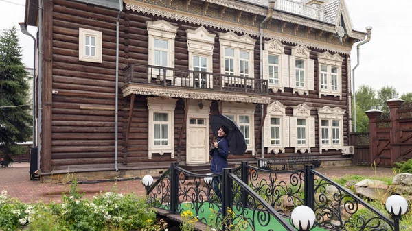 Frau Mit Schwarzem Regenschirm Auf Dem Hintergrund Eines Alten Holzgebäudes — Stockfoto