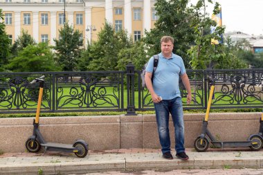 Yetişkin bir adam akıllı telefon uygulaması ile elektrikli scooter kiralıyor..