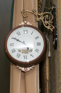 Restoranda kahverengi çerçeveli büyük yuvarlak duvar saati..