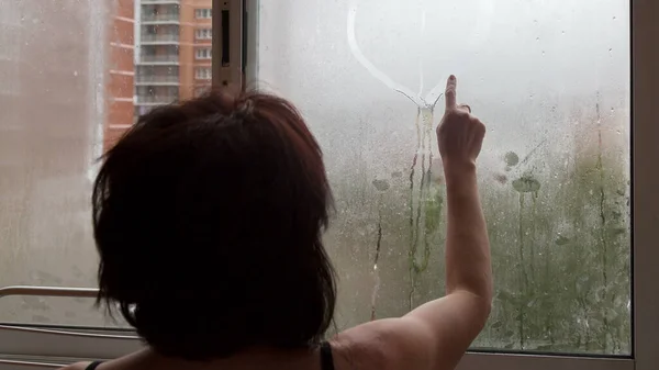 Woman Draws Heart Her Finger Wet Fogged Window Concept Romance — стоковое фото