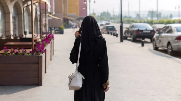 一人のイスラム教徒の女性が空の大都市を歩いてリアビュー — ストック写真