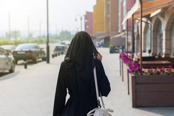 単一のイスラム教徒の女性は 空の大都市の背面ビューを歩く — ストック写真