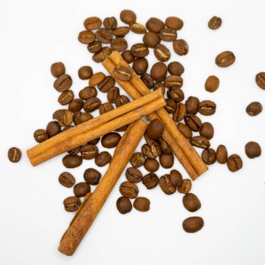 Tarçın çubukları ve kahve çekirdekleri beyaz arka planda, izole edilmiş..