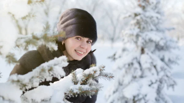 Yaşlarında Gülümseyen Bir Kadın Karla Kaplı Bir Ladin Dalının Arkasından — Stok fotoğraf