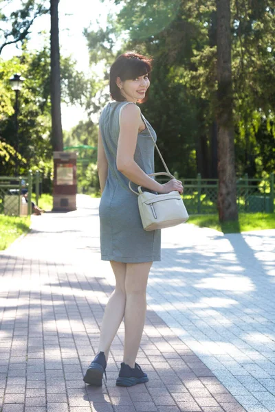 Woman Walking Smile Short Striped Dress Sneakers Brick Path Sunny — Stock Photo, Image