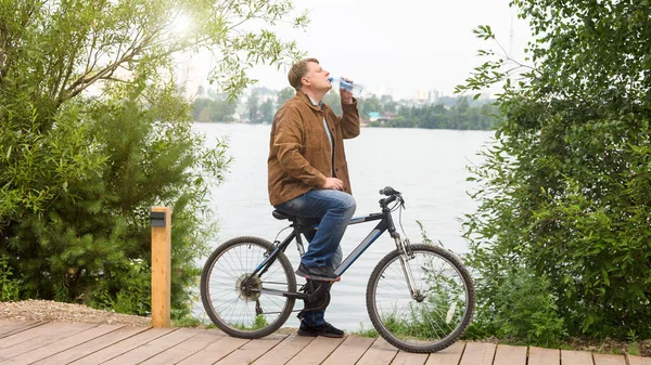 가지고 자전거를 가다가 멈추어 마셨다 — 스톡 사진
