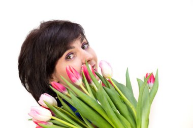 Güzel bir gülüşü olan esmer bir kızın portresi. Bir buket taze lalesi var, izole edilmiş, beyaz bir arka plan..