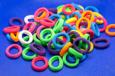 Mavi arka plandaki küçük kızlar için renkli parlak lastik bantlar..