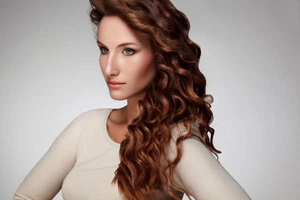 Uzun kıvırcık saçlar ile güzel bir genç kadın — Stok fotoğraf