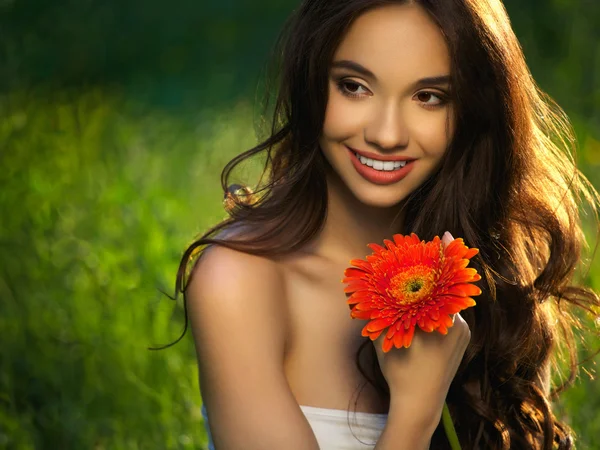 Mooi meisje met rode bloemen. prachtige model vrouw gezicht. — Stockfoto