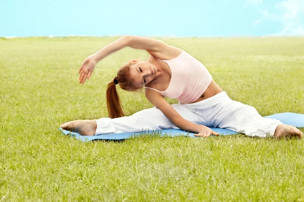 Mooie vrouw doen stretching oefening tegen aard backgro — Stockfoto