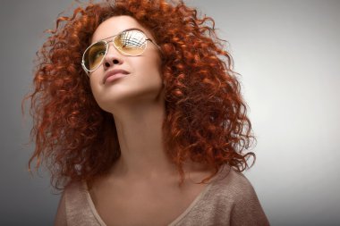 Kızıl saçlı. güzel bir kadın kıvırcık uzun saçlı, sunglases