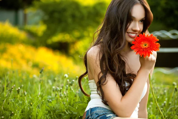 Όμορφη γυναίκα με λουλούδι ζέρμπερα απόλαυση της φύσης εναντίον φυ — Φωτογραφία Αρχείου