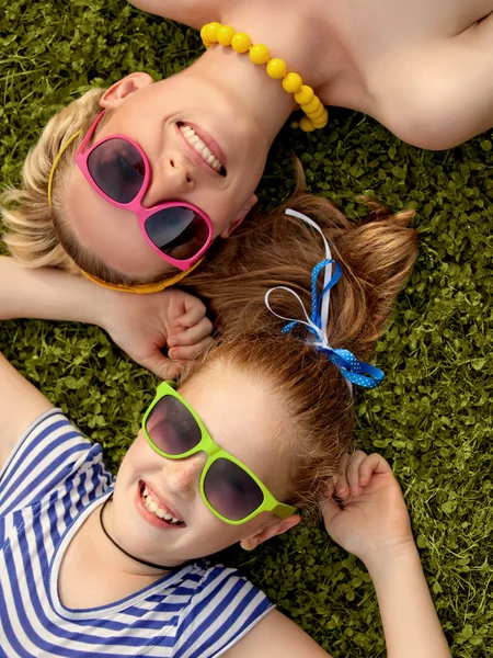 Jonge moeder en dochter laing in gras. kleurrijke sunglass — Stockfoto