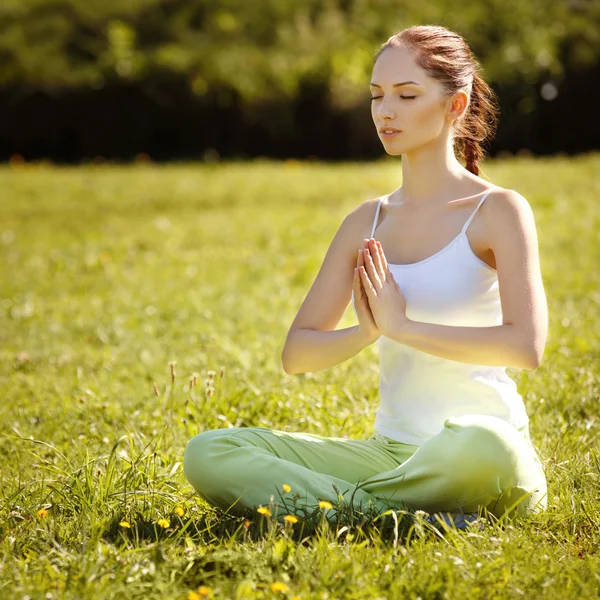 Mujer joven y hermosa haciendo ejercicios de yoga. Fondo de yoga — Foto de Stock