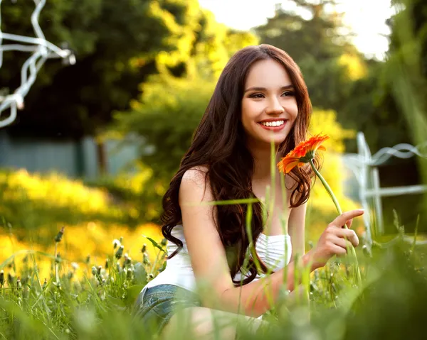 Gyönyörű nő élvezi természet ellen Natu Gerbera virággal — Stock Fotó