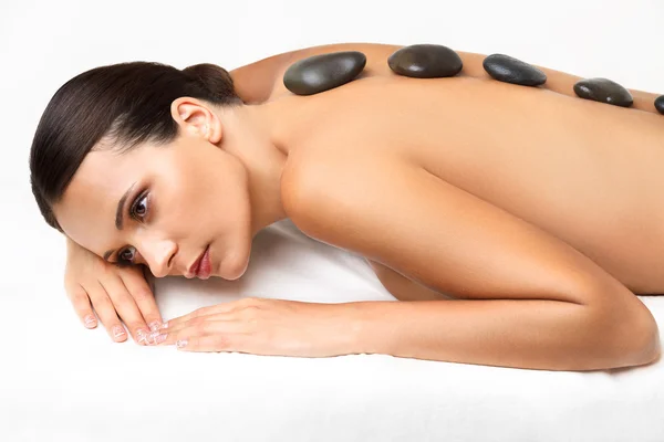 Masaje de piedra. Hermosa mujer consiguiendo spa piedras calientes masaje — Foto de Stock