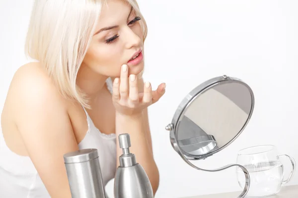 Woman Looking at Her Face in the Mirror — Stock Photo, Image