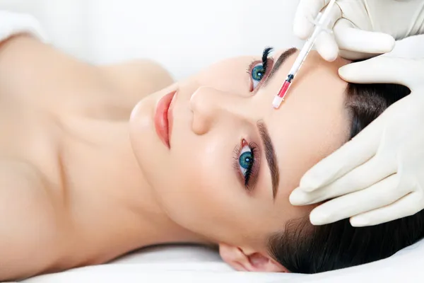 Una mujer hermosa recibe inyecciones. Cosmetología. Cara de belleza — Foto de Stock