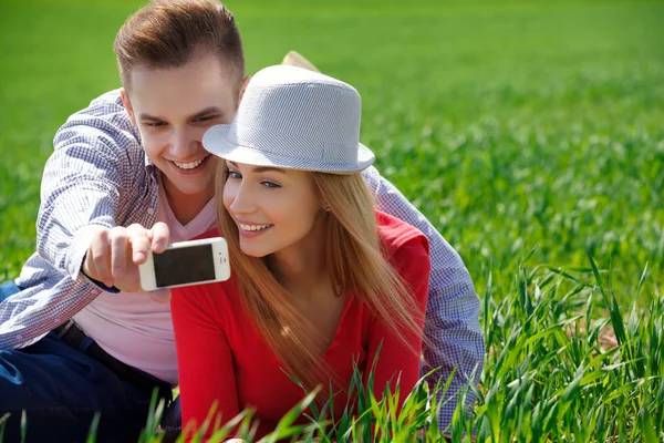 Пара з телефоном знімає самопортрет у парку — стокове фото
