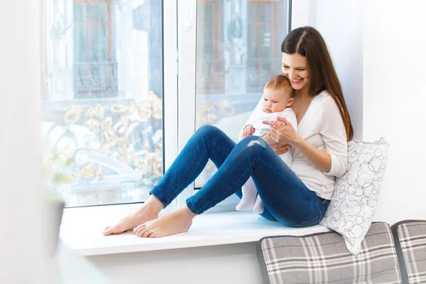 Mère et bébé sur le rebord de la fenêtre — Photo