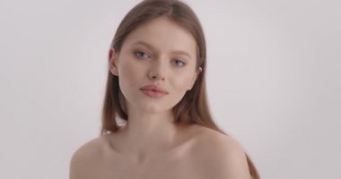 Güzel surat. Çıplak omuzlu, stüdyoda şehvetli pozlar veren çarpıcı genç bir bayan. Kafkas kadın portresi, doğal sarı saçlı ve sağlıklı pürüzsüz yüzlü..