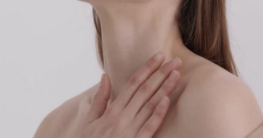 Vücut bakımı. Stüdyoda vücut losyonu süren çıplak omuzlu çekici genç bir kadın. Kafkasyalı kadın teniyle ilgileniyor.. 