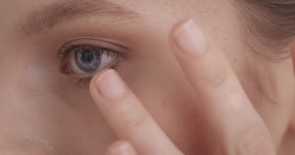 面部皮肤护理 一个迷人的年轻女子 蓝眼睛 轻柔地触摸着她光滑的健康肌肤 脸的一半美容术概念 — 图库视频影像