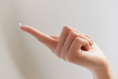 Kontak göz lensleri. Doğal Tırnaklı Kadın Elleri Göz Lens Tutuyor. Parmağında şeffaf göz merceği olan kız parmağının yakın çekimi. Yüksek Çözünürlüklü Resim