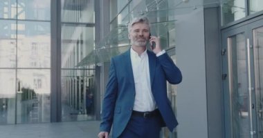 İş adamı, güneşli bir günde sokakta cep telefonunu kullanıyor. Son sınıf öğrencisi molada akıllı telefondan konuşuyor. Olgun Adam Ofis Binası Yakınındaki İş Arkadaşına Çağrı