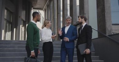 Business Partners Discussing Project Together. Successful Business People During the Break at the Street. Senior Young and Multiracial Colleagues Chatting 