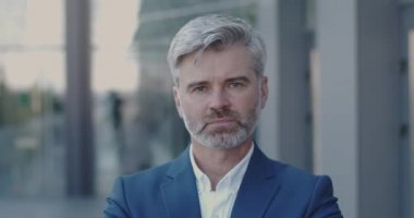 Yetişkin İş Adamı 'nın Portresi Tek Başına Gülümseyen ve Bakan Kamera. Modern Cam Ofis Merkezi 'nin yakınında başarılı bir erkek işadamı duruyor. İş İnsanları Konsepti 