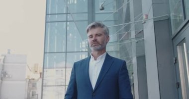 Sokaktaki Yakışıklı Kıdemli Girişimcinin Orta Boyutlu Portresi. Akıllı adam kollarını kavuşturup kameraya bakıyor, gülümsüyor. E-İş Fikirleri Düşünen Adam, E-Ticaret Yatırım Stratejisi 