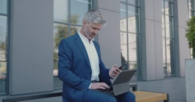 Ofis kâtibi dışarıda tablet üzerinde çalışıyor. Olgun Adam sunum yapmaya hazırlanıyor. Resmi Takım Elbiseli Kıdemli İşadamı Ortaklarla Görüşmeden Önce Bench 'te oturuyor 