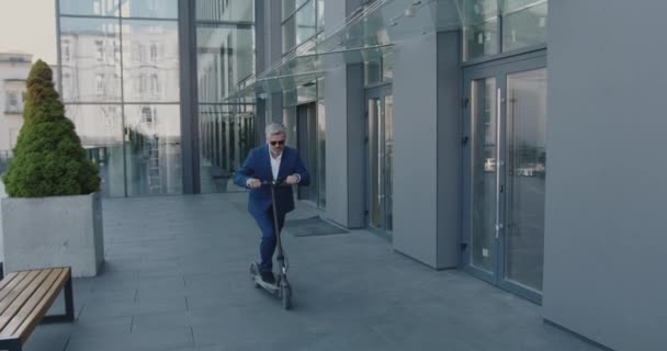白种人高级商人在城市上下班时穿着合身的电动车 成功的办公室职员户外 — 图库视频影像