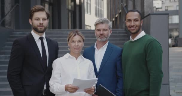 4人のホワイトカラー労働者の肖像画企業のオフィスの近くで 都市の背景を着用してください 休憩中に通りに立つビジネスマン — ストック動画