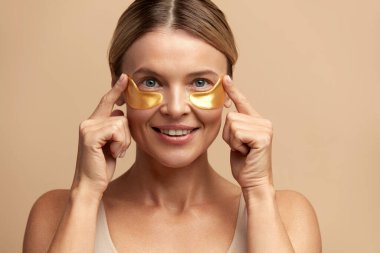 Göz Derisi Güzeli. Doğal makyajlı, sağlıklı taze derili ve göz altı kolajen hidrojen göz bantlı güzel kadın yüzü. Yüksek Çözünürlük 