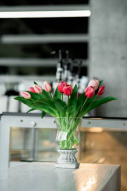 Bahar çiçekleri vazoda laleler duruyor.