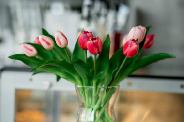 Bahar çiçekleri vazoda laleler duruyor.