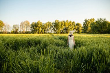 Kız yeşil bir tarlada yürüyor